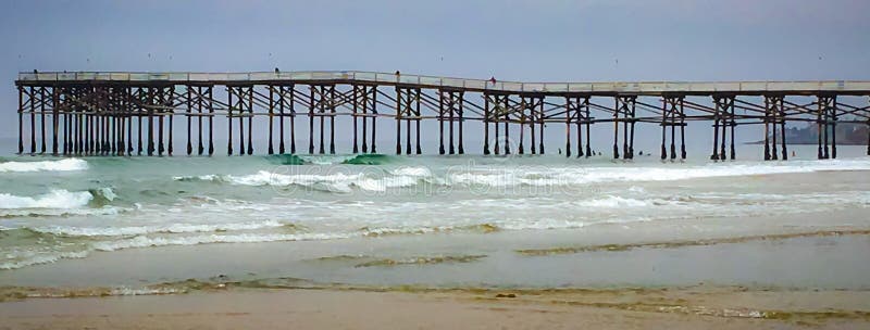 Krajina záber pláž, oceán, vlny a pier postavil sa do oceánu s mnohými opakujú geometrické vzory sú uvedené v tejto staré, ručne vyrobené rybárske mólo v San Diegu, Kalifornia.