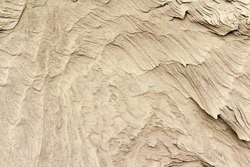 Patterns of erosion of sand in the background