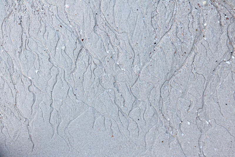 Sand background.The patterns of water erosion sand on the beach.