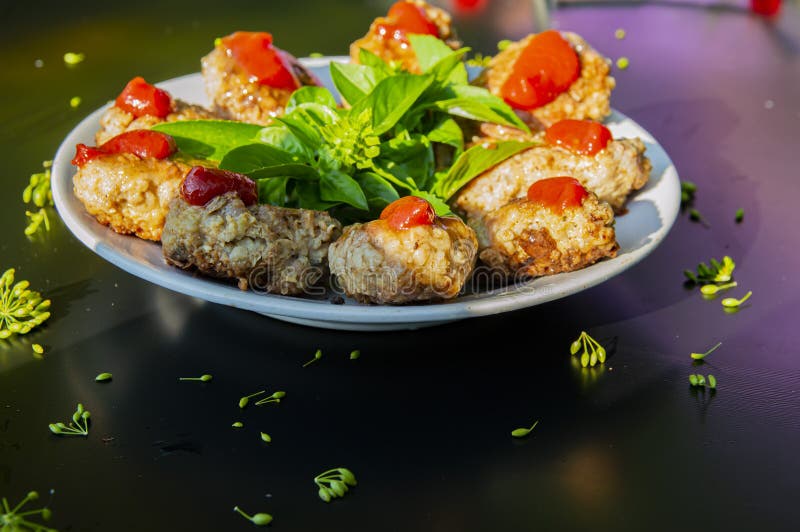 Patties κρέατος με τα πράσινα σε ένα άσπρο πιάτο σε ένα μαύρο υπόβαθρο στοκ φωτογραφίες Patties κρέατος με τα πράσινα σε ένα άσπρο πιάτο σε ένα μαύρο υπόβαθρο στοκ φωτογραφίες