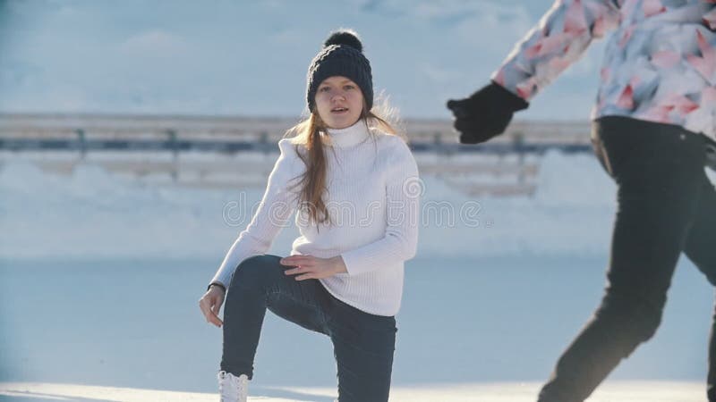 Pattinatore russo della ragazza che pattina, cadente e stante su su una pista di pattinaggio sul ghiaccio pubblica