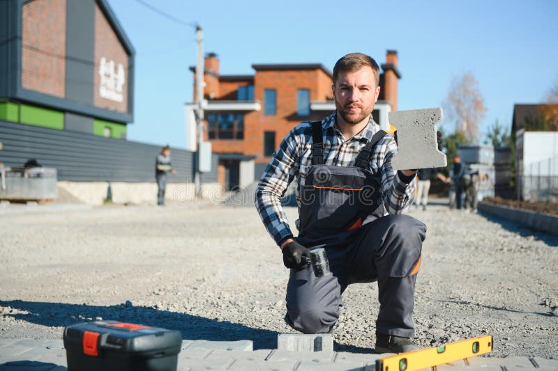 Paver laying driveway pavement out of concrete pavement blocks stock photos