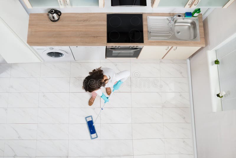 High Angle View Of Woman Mopping Floor In Kitchen. High Angle View Of Woman Mopping Floor In Kitchen