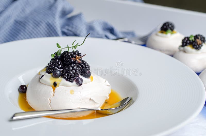 Pavlova efterrätt med sås för passionfrukt royaltyfri bild Pavlova efterrätt med sås för passionfrukt royaltyfri bild