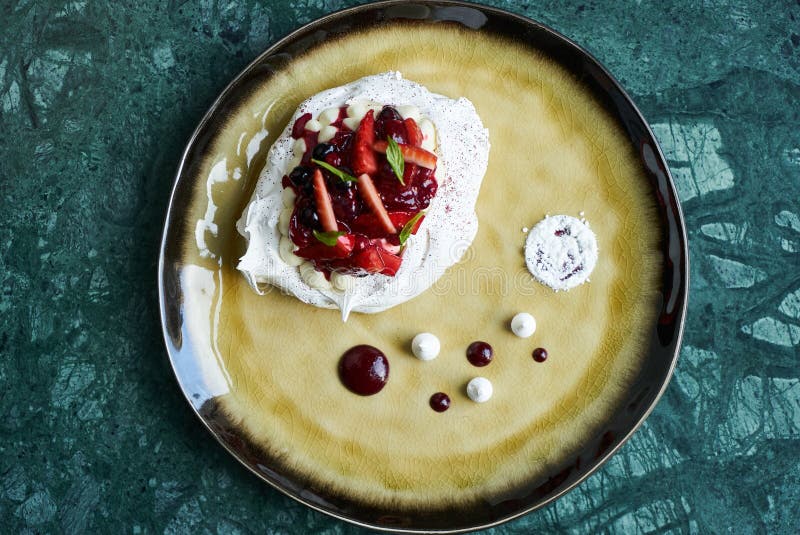 Pavlova meringue cake with fresh berries and custard cream