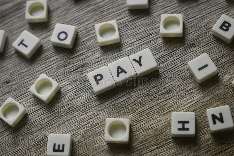 Pay word made of square letter word on wooden background stock photo