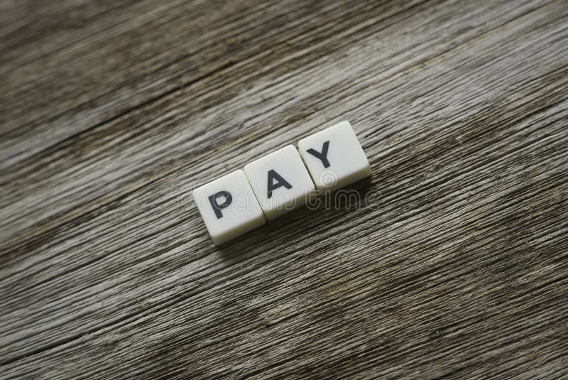 Pay word made of square letter word on wooden background stock photography