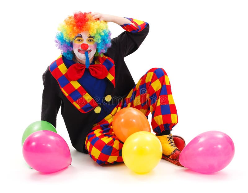 Clown sitting on floor, scraping his head, surrounded with colorful balloons. Clown sitting on floor, scraping his head, surrounded with colorful balloons