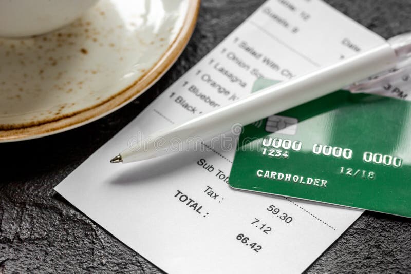Paying Check For Lunch In Cafe With Credit Card On Dark Table