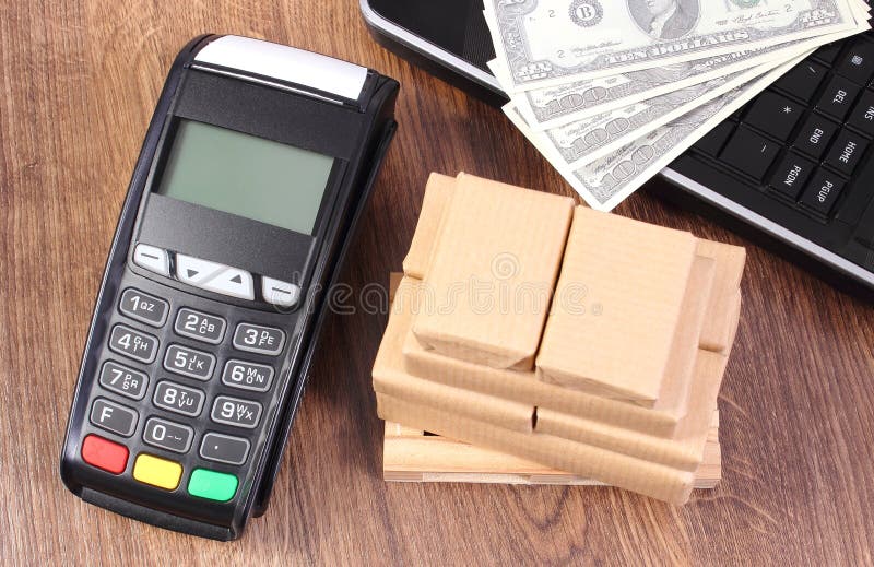 Payment terminal with currencies dollar, laptop and boxes on pallet, paying for shipping and products stock images Payment terminal with currencies dollar, laptop and boxes on pallet, paying for shipping and products stock images