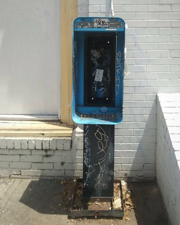 Payphone Remnants and Brick Building Facade