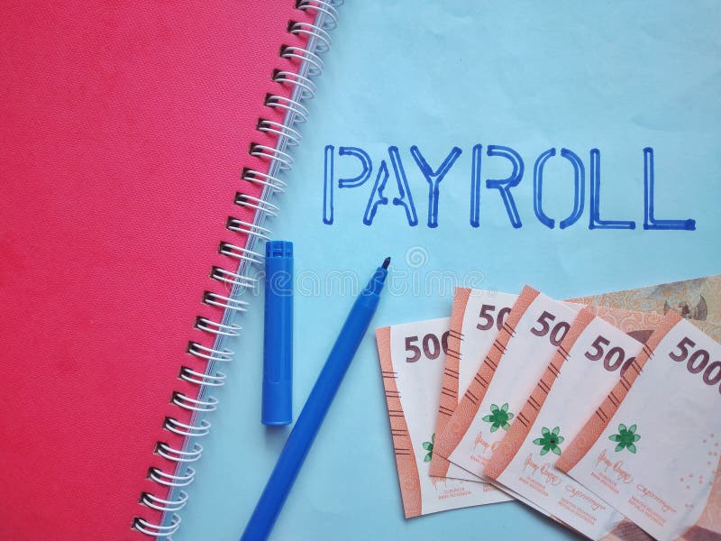 Payroll word on blue paper with money and pen royalty free stock photography