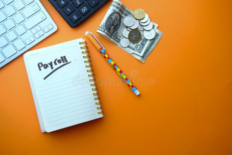 Payroll word on notepad with calculator on color background. stock photography