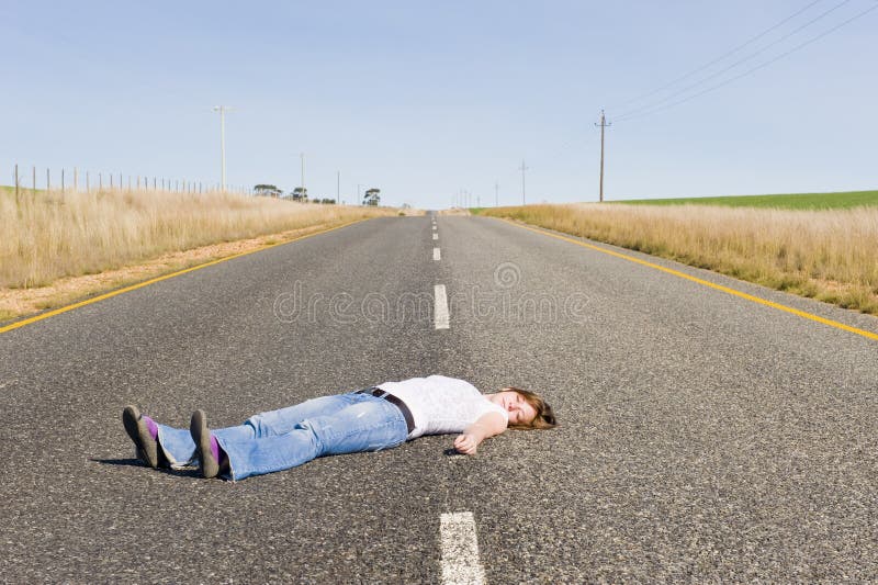 Pays-route abandonnée avec la fille se situant dans le middl image libre de droits Pays-route abandonnée avec la fille se situant dans le middl image libre de droits