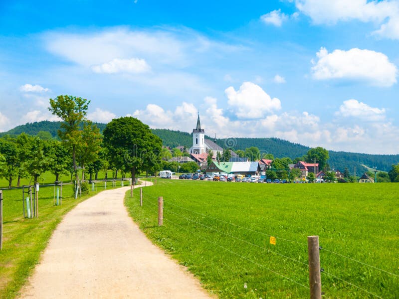 Paysage d'été avec le pré vert luxuriant, la route de campagne et l'église rurale blanche Prichovice, Bohême du nord, tchèque photo libre de droits Paysage d'été avec le pré vert luxuriant, la route de campagne et l'église rurale blanche Prichovice, Bohême du nord, tchèque photo libre de droits