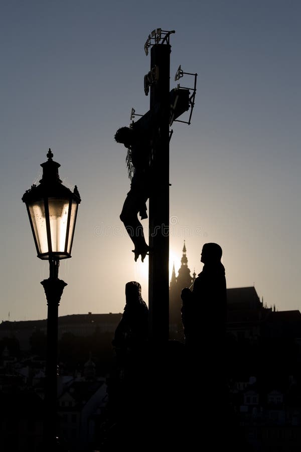 Sunset back light view on statuary of the Calvary Cross (Crucifix from 1629, statues by Emanuel Max 1861) standing on Charles Bridge with St Vitus cathedral on the background. Sunset back light view on statuary of the Calvary Cross (Crucifix from 1629, statues by Emanuel Max 1861) standing on Charles Bridge with St Vitus cathedral on the background.