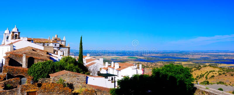 Medieval Monsarraz village and Church bells towers. Alentejo plain and Alqueva Lake landscape. In 1167 Monsaraz, that stands inside the castle walls, was conquered to the moors and it becames the most important portuguese sentry over the Guadiana river, guarding the border with the realm of Castile, now Spain. Alentejo region, South of Portugal. Medieval Monsarraz village and Church bells towers. Alentejo plain and Alqueva Lake landscape. In 1167 Monsaraz, that stands inside the castle walls, was conquered to the moors and it becames the most important portuguese sentry over the Guadiana river, guarding the border with the realm of Castile, now Spain. Alentejo region, South of Portugal.