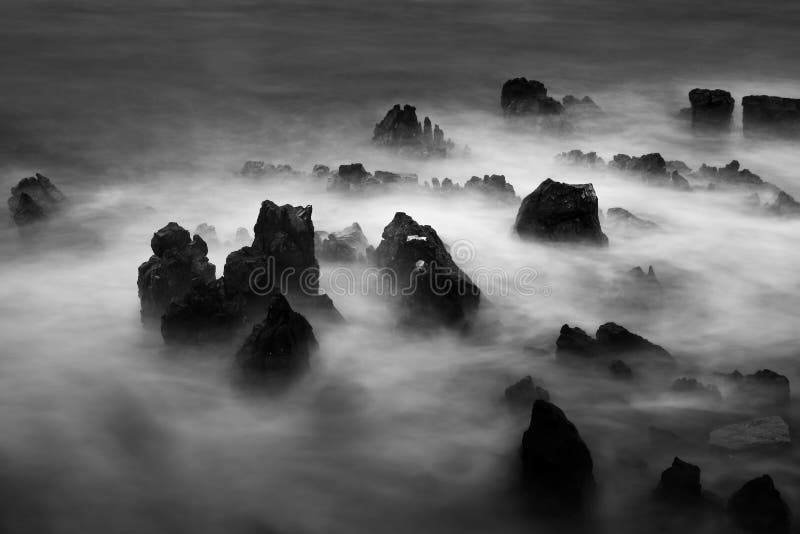 Paysage marin dramatique avec des vagues écrasant des roches, faites avec la longue exposition images stock Paysage marin dramatique avec des vagues écrasant des roches, faites avec la longue exposition images stock