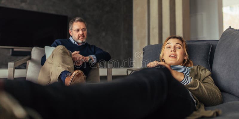 Paziente femminile che discute le sue edizioni con lo psicologo fotografie stock libere da diritti Paziente femminile che discute le sue edizioni con lo psicologo fotografie stock libere da diritti