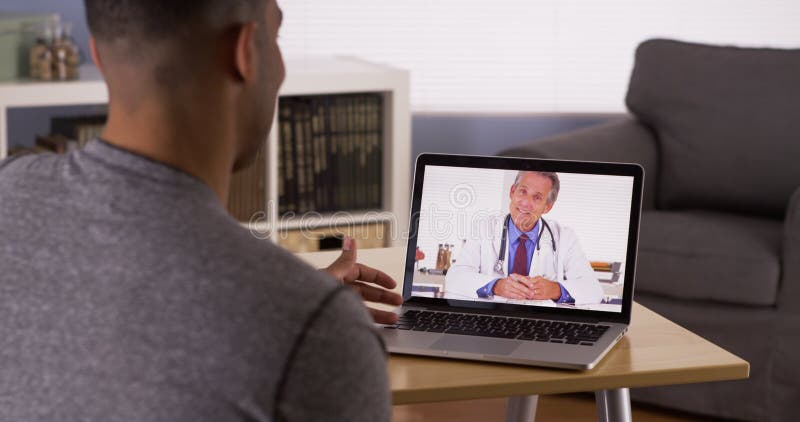 Paziente nero che discute i problemi sanitari con medico online fotografie stock libere da diritti Paziente nero che discute i problemi sanitari con medico online fotografie stock libere da diritti