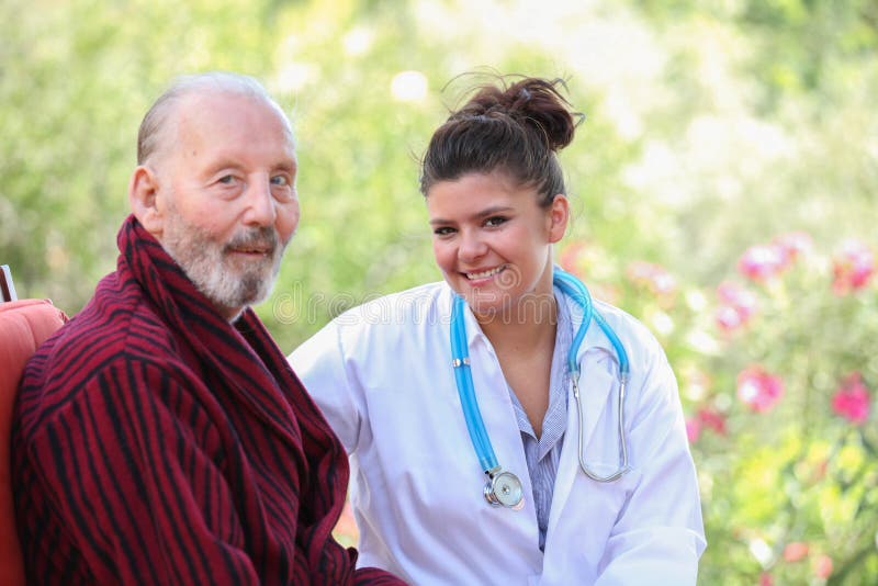 Paziente senior sorridente con medico o l'infermiere immagine stock libera da diritti Paziente senior sorridente con medico o l'infermiere immagine stock libera da diritti