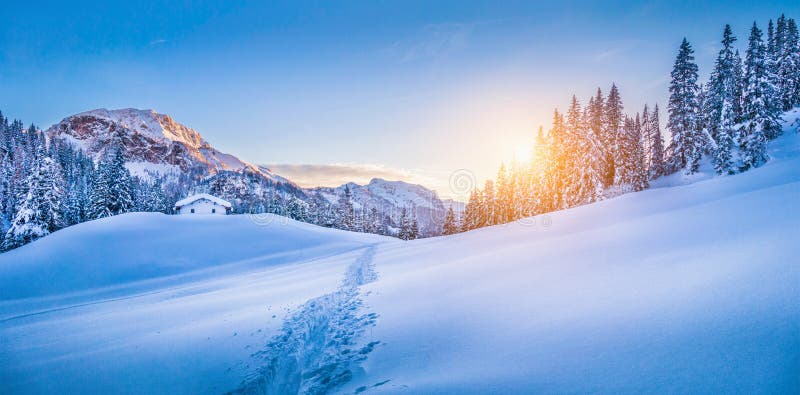 País das maravilhas do inverno nos cumes com o chalé da montanha no por do sol