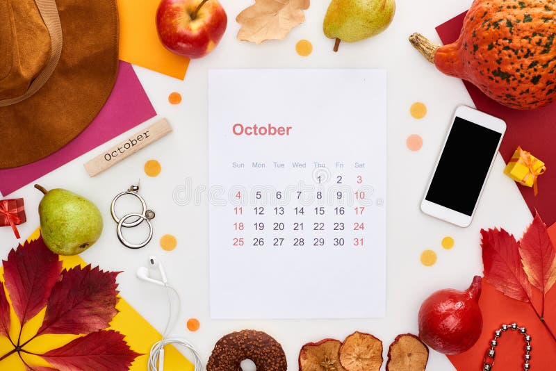 October calendar page, hat, smartphone, fruits, pumpkin, dry leaves, multicolored papers, wooden block with november inscription  on white,stock image. October calendar page, hat, smartphone, fruits, pumpkin, dry leaves, multicolored papers, wooden block with november inscription  on white,stock image