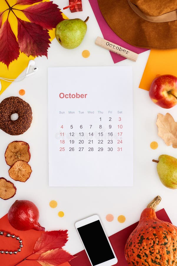 October calendar page, hat, smartphone, fruits, pumpkin, dry leaves, multicolored papers, wooden block with october inscription isolated on white,stock image. October calendar page, hat, smartphone, fruits, pumpkin, dry leaves, multicolored papers, wooden block with october inscription isolated on white,stock image