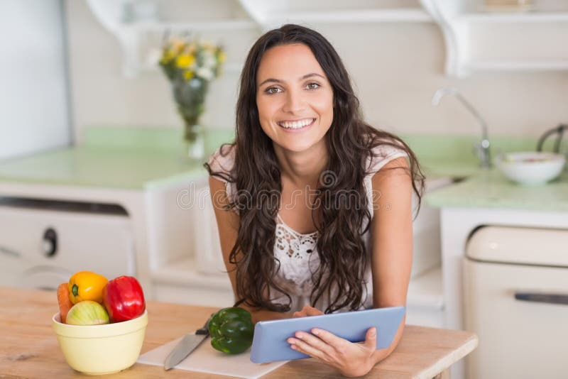 PC da tabuleta e salada de utilização morenos bonitos da preparação imagens de stock PC da tabuleta e salada de utilização morenos bonitos da preparação imagens de stock