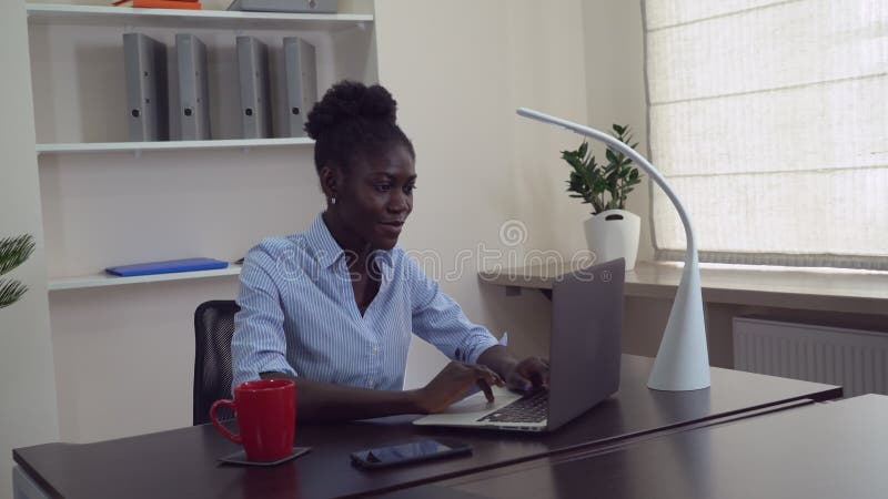 PC femenina africana del uso en el trabajo