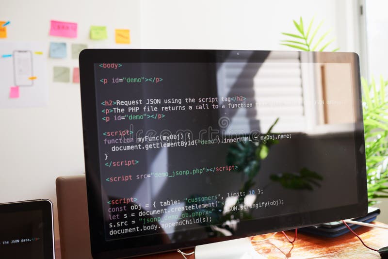 Натюрморт с экраном ПК, демонстрирующим код Javascript, на столе в офисе стоковая фотография