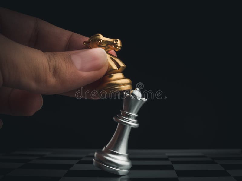 Peça de xadrez de rainha dourada de close-up em mão humana em