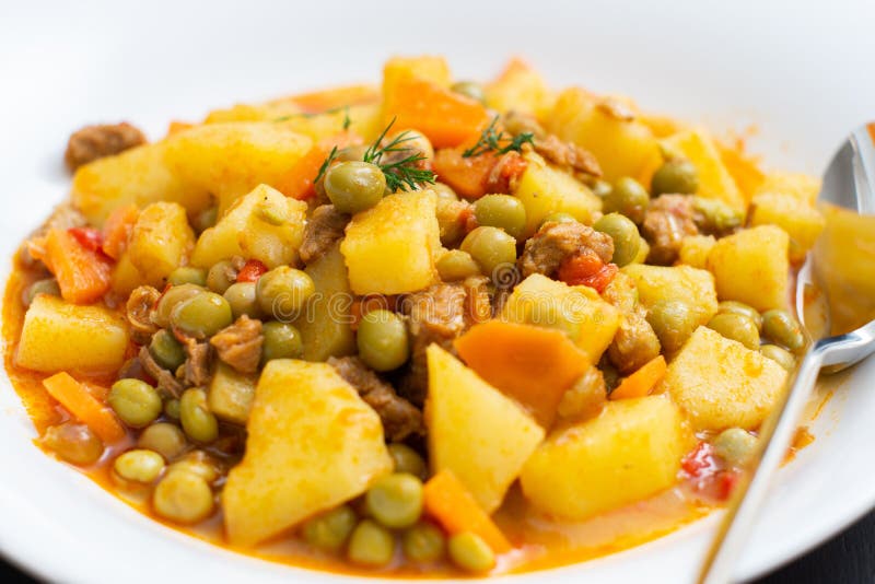 Pea Dish with Potatoes, Carrots and Meat in White Plate Stock Photo