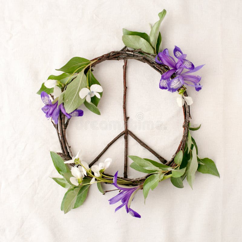 Peace sign, symbol of natural material - flowers, leaves, wooden sticks on tissue white background.