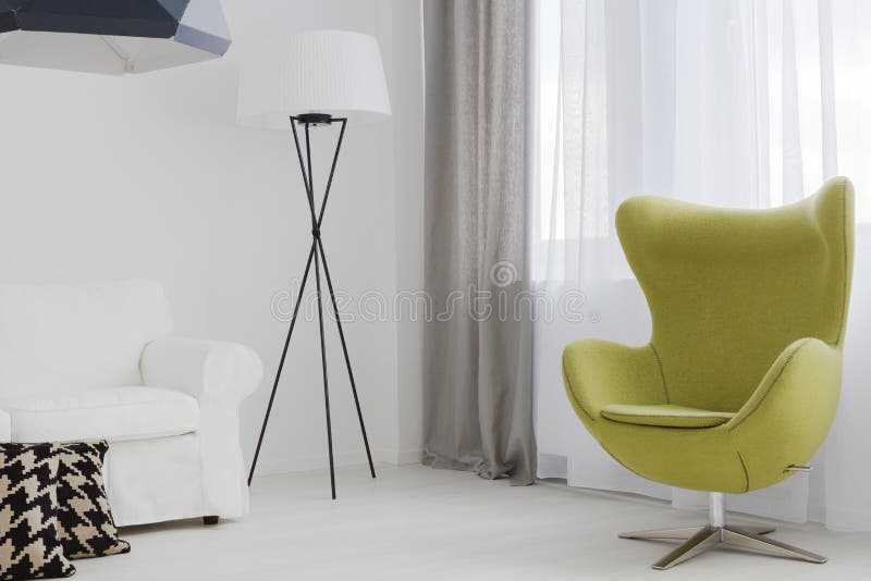 Close-up of a very bright room corner with a unique floor lamp and a swivel egg chair. Close-up of a very bright room corner with a unique floor lamp and a swivel egg chair