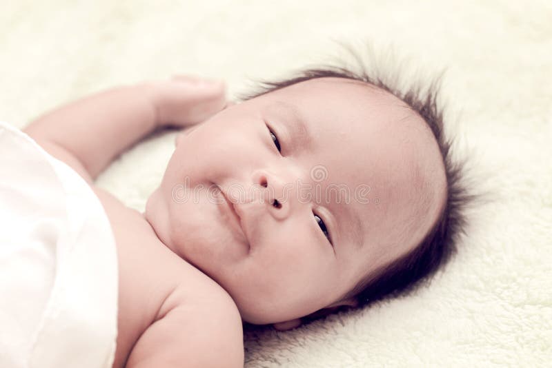 Peaceful Baby Lying on a Bed while Sleeping in a Bright Room Stock