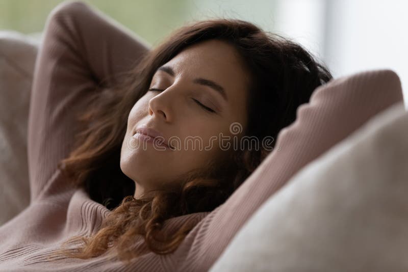 Peaceful Hispanic Woman Relax On Sofa At Home Sleeping Stock Image