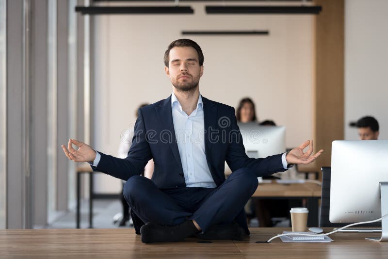 Peaceful businessman meditating with eyes closed at workplace royalty free stock photo Peaceful businessman meditating with eyes closed at workplace royalty free stock photo
