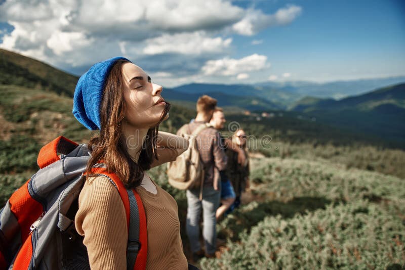 Closed eyes. Calm relaxed young hiker standing with her eyes closed and enjoying fresh air in the mountains. Closed eyes. Calm relaxed young hiker standing with her eyes closed and enjoying fresh air in the mountains