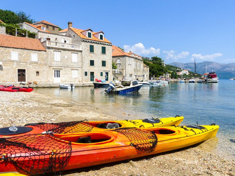 Peacefull kust- plats på den Dalmaitia kusten av Kroatien med sportkajakfartyg och feriehus royaltyfria foton Peacefull kust- plats på den Dalmaitia kusten av Kroatien med sportkajakfartyg och feriehus royaltyfria foton