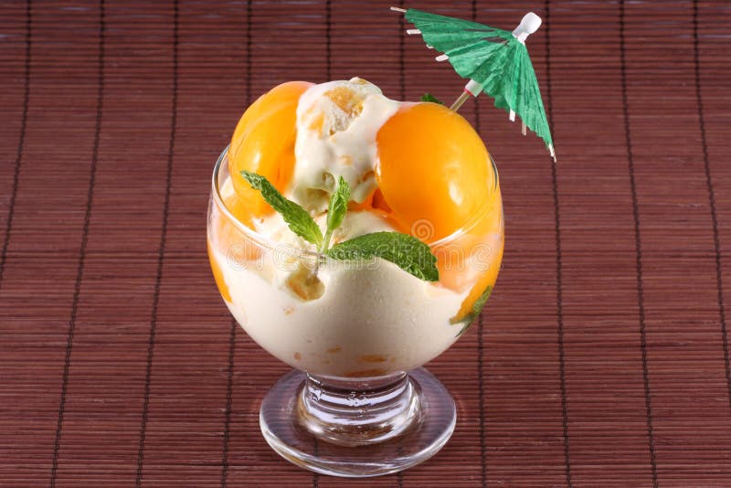 Peach ice cream with mint leaves and a little umbrella