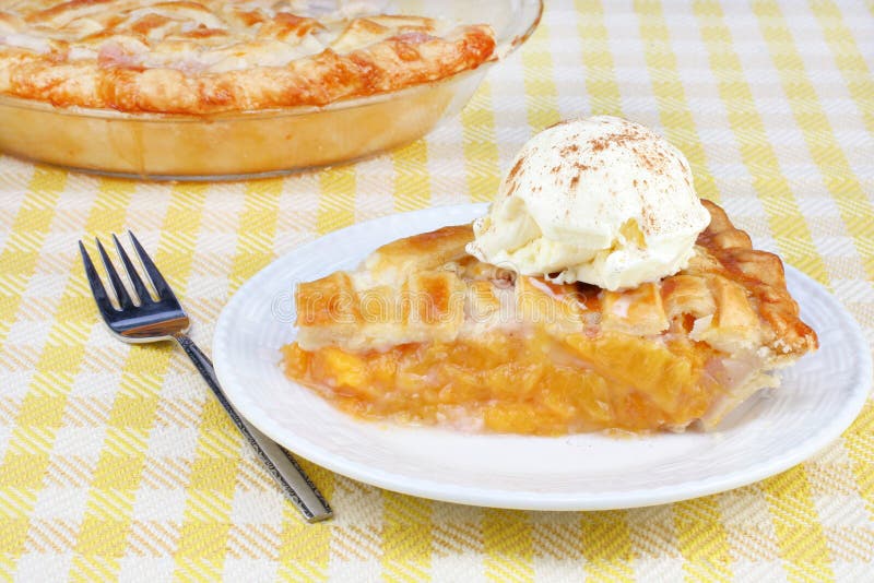 Peach pie ala mode with vanilla ice cream sprinkled with cinnamon.
