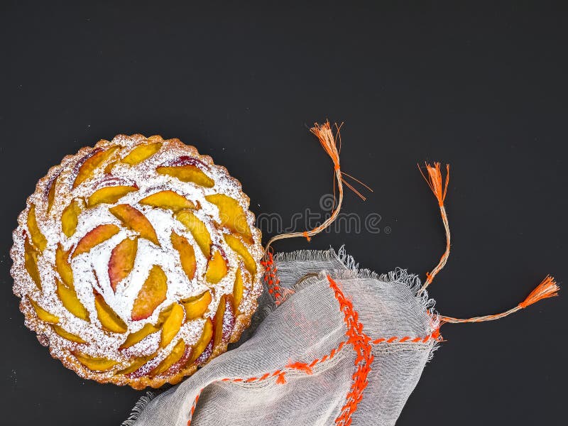 Peach pie with sugar powder over a linen table cloth on dark stock photography Peach pie with sugar powder over a linen table cloth on dark stock photography