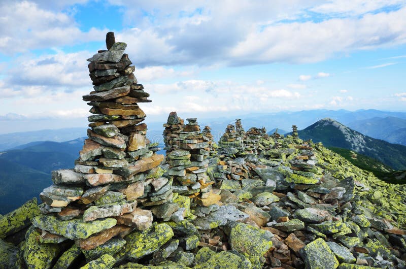 Peak of mountain with moraine and stone landmarks.