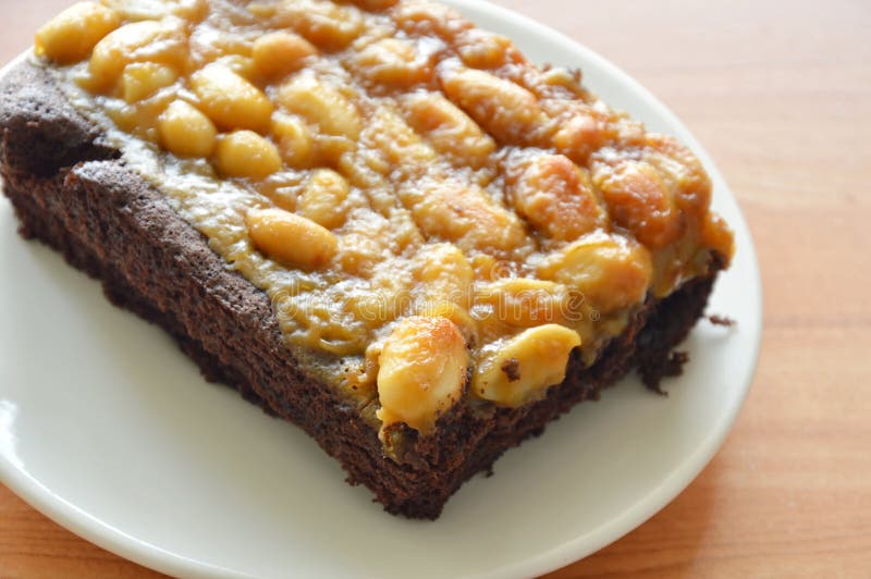 Peanut Butter Caramel Topping Dark Chocolate Cake on Plate Stock Photo
