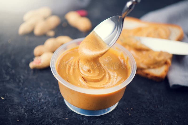 Peanut butter. Creamy smooth peanut butter in a jar on a table. Spoon of Natural nutrition royalty free stock photography Peanut butter. Creamy smooth peanut butter in a jar on a table. Spoon of Natural nutrition royalty free stock photography