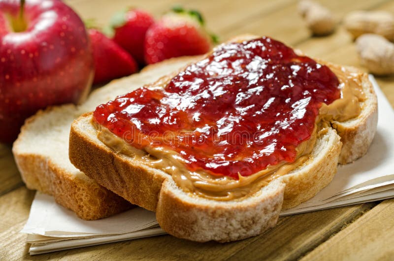 Burro di arachidi e gelatina di panino con la mela, fragole, arachidi in guscio.