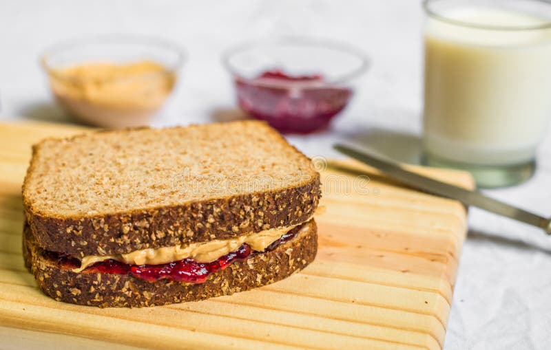 Peanut butter and jelly sandwich on a wooden board against white background stock images Peanut butter and jelly sandwich on a wooden board against white background stock images