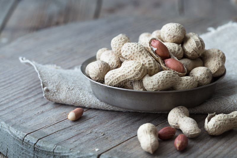 Peanuts in the shell and peeled close up in a cup. Background with peanuts. Roasted peanuts in the shell and peeled on a backgroun stock photos Peanuts in the shell and peeled close up in a cup. Background with peanuts. Roasted peanuts in the shell and peeled on a backgroun stock photos