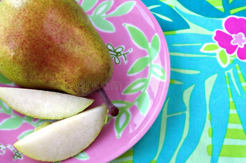 Pear on colorful floral plate stock photo